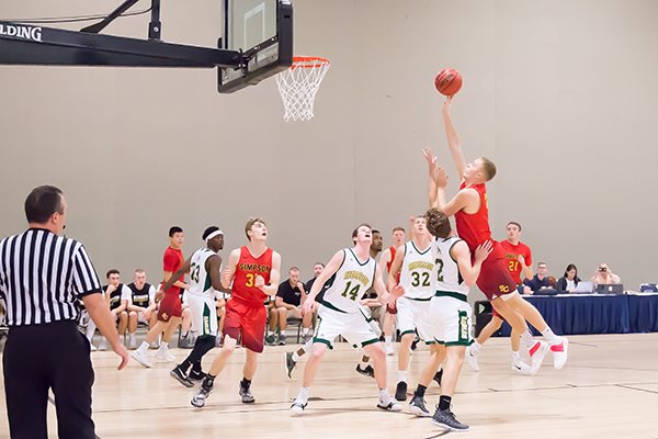 A player in a white jersey shoots over a defender in a navy jersey