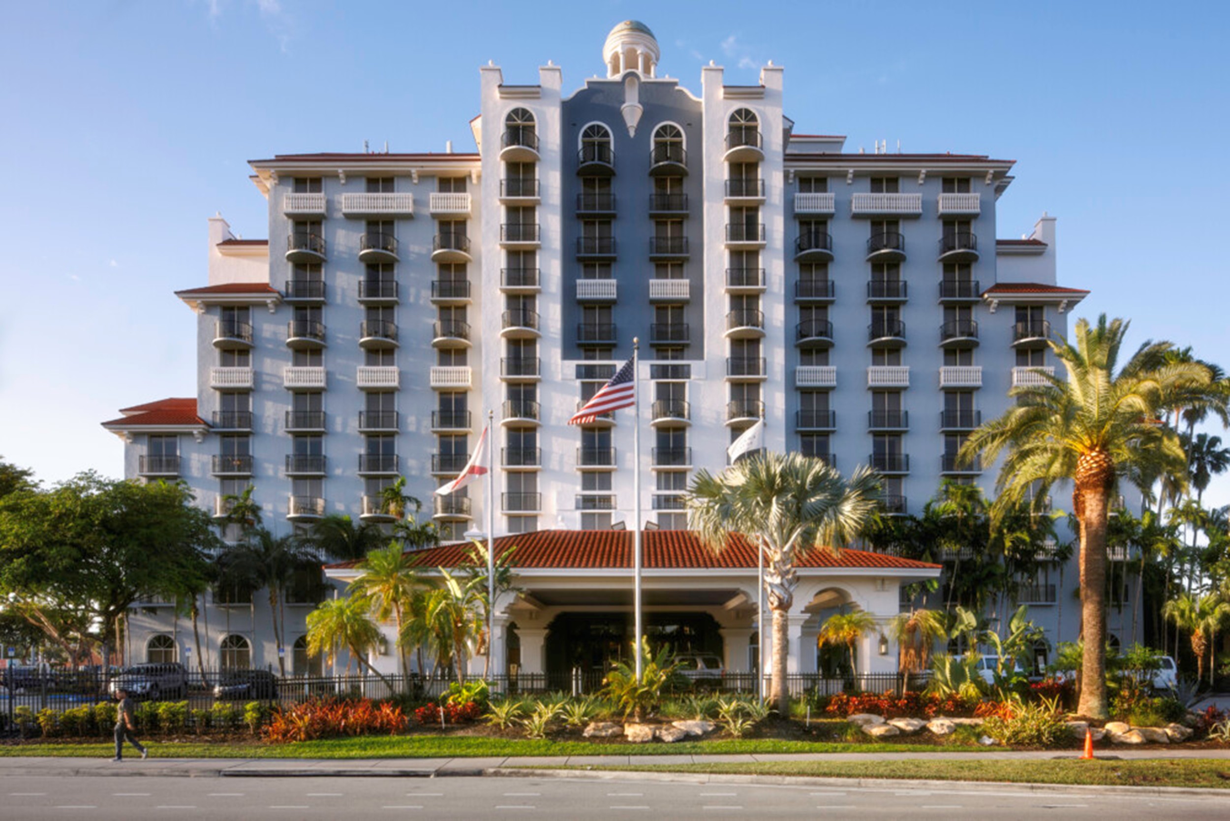A hotel tower and entrance at dusk